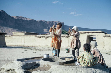 むらの井戸で水汲みをする少女の画像